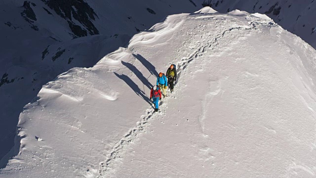 登山队员们正在穿越一个积雪的山脊视频素材