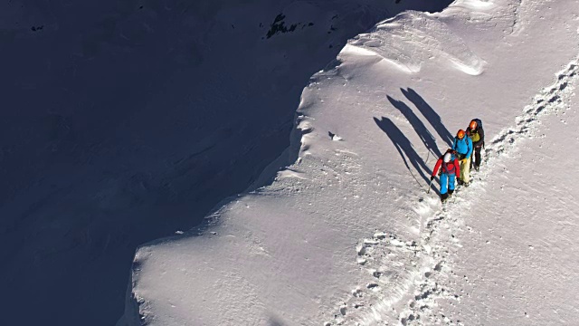 LD三个人在阳光下走在积雪的山脊上视频素材