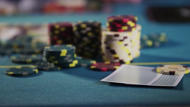 扑克筹码堆在赌桌上;一只手伸进去，偷偷看了两张牌——黑桃A和黑桃8。视频下载