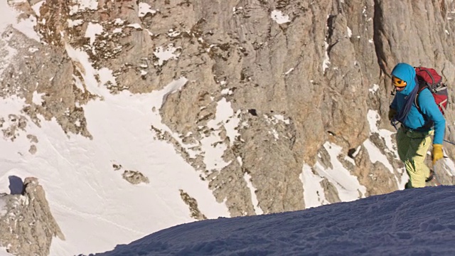 用绳子把走向山顶的登山运动员捆起来视频素材