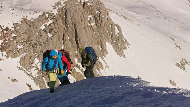 在一个阳光明媚的日子里，登山队员爬上了雪山视频素材