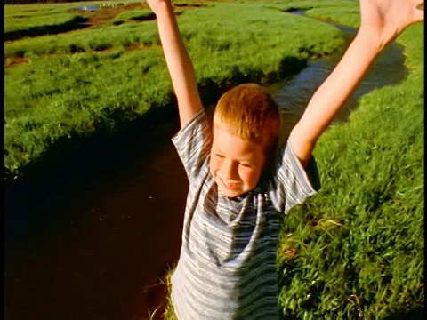 在俄勒冈州喀斯喀特山脉的溪流/火花草地上，一只鹤射杀了一个举起手臂的男孩视频下载