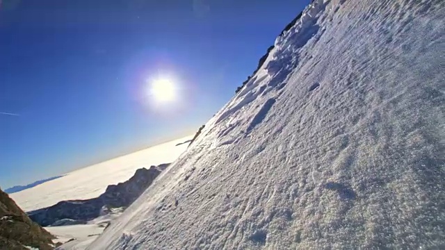 SLO MO滑雪旅游在一个阳光明媚的日子从山上滑雪下来视频素材