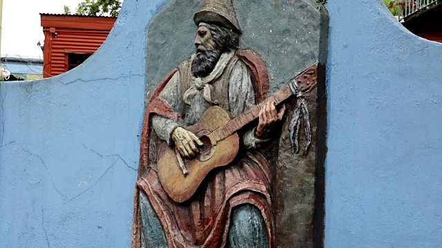 阿根廷布宜诺斯艾利斯拉博卡彩色街头男子与吉他雕塑在墙上视频下载