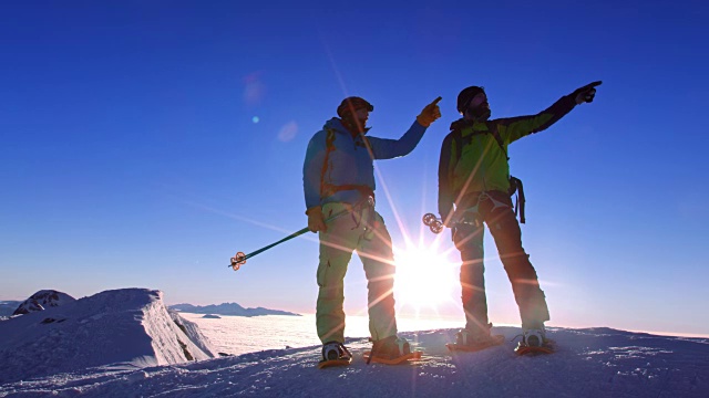 日落时分，穿雪鞋的人在山顶讨论路线视频下载