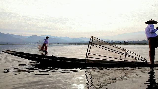 在缅甸的茵莱湖上，当地人用锥形渔网划船捕鱼视频素材