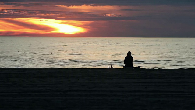 WS剪影的女人坐在海滩上享受饮料/洛杉矶，加利福尼亚，美国视频素材