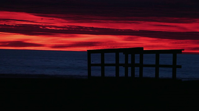 日落时分，一名男子走过海滩的剪影/美国加州洛杉矶视频素材