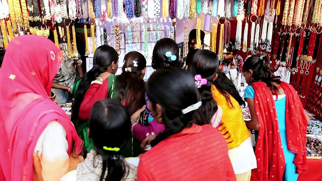 印度拉贾斯坦邦普什卡，身着传统服饰的女性在当地市场摊位购买珠宝视频下载