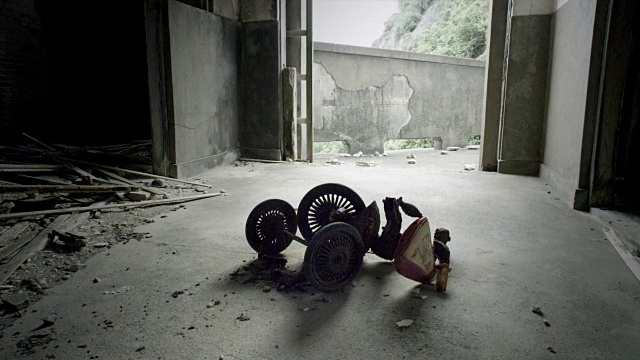 关闭的鞋子和一个孩子的三轮车在一个废弃的羽岛的建筑内视频素材