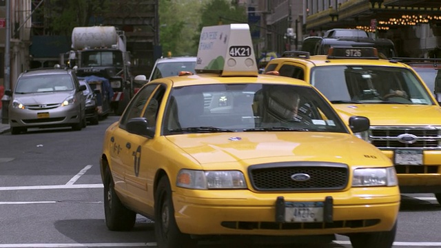 这是出租车和其他车辆转向曼哈顿一条长长的大街的照片视频素材