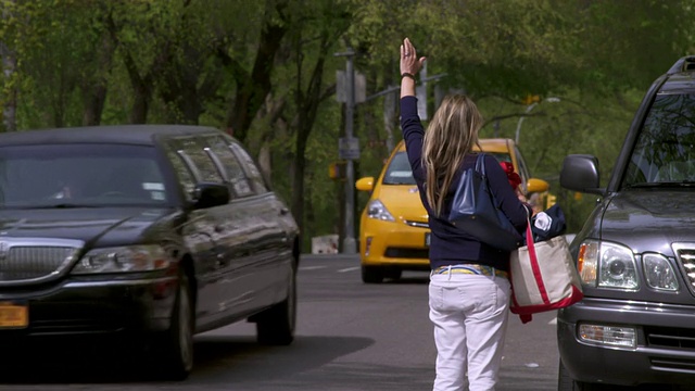 拍摄于曼哈顿中央公园附近，一名女子试图拦下一辆出租车但未能成功。视频素材