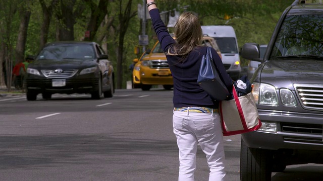 拍摄于曼哈顿中央公园附近，一名女子试图拦下一辆出租车但未能成功。视频素材
