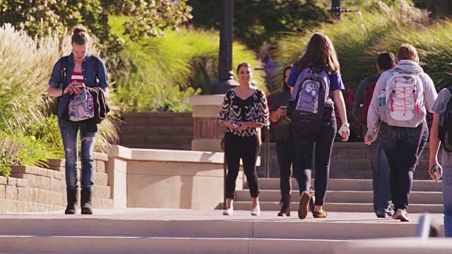 大学生们走在校园里。视频下载