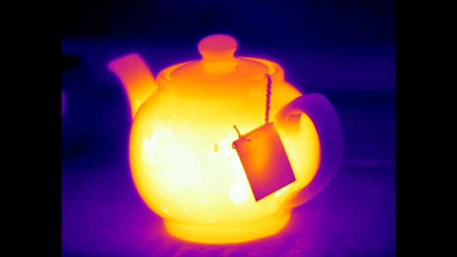 一个热茶壶冲泡和一个温暖的空茶杯的红外视频视频下载