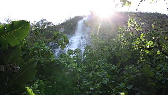 拉焦点倾斜到丛林瀑布，阳光背后视频素材