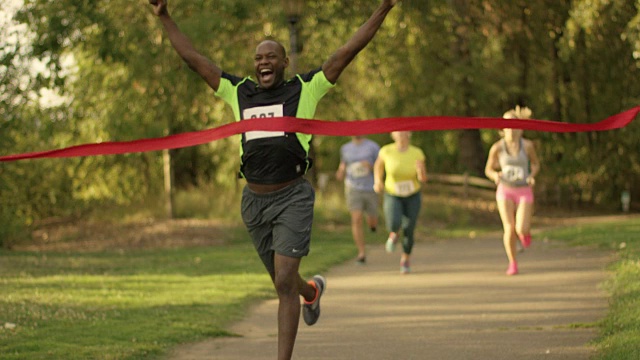 非洲裔美国男子在赛跑中穿过丝带和终点线视频下载