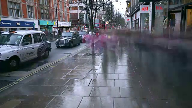 在一个潮湿的冬日里，一大群人趁着一月份的销售旺季，沿着牛津街快速购物视频素材