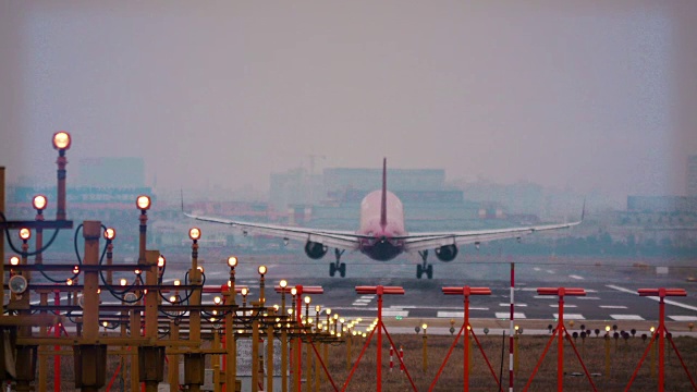 飞机在上海虹桥机场降落。跑道灯光在前景。视频下载