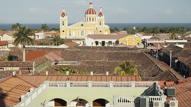 格拉纳达-尼加拉瓜的天际线从钟楼拉默塞德教堂的有利位置。在这段4K视频中，我们可以看到前景中的一些屋顶和庭院，背景是带有圆顶的殖民风格大教堂和尼加拉瓜科西博尔卡湖视频下载