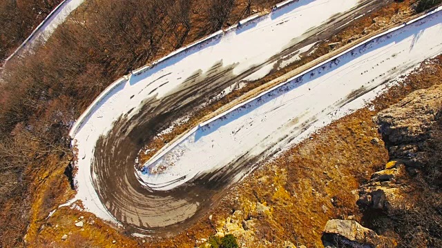 空中冬季蜿蜒的山路在阳光明媚的日子里视频下载
