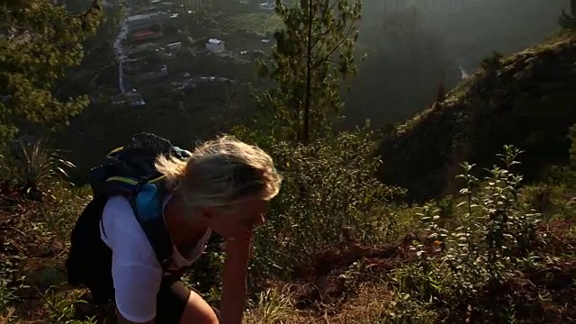 女人爬上山谷纵览，停下来看了看视频素材