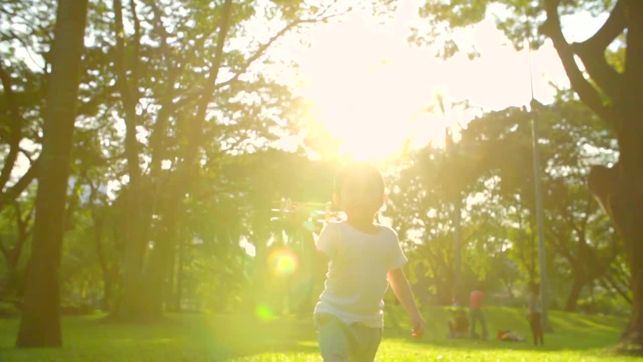 高清:快乐的孩子在公园里玩木制飞机(慢镜头)..视频素材
