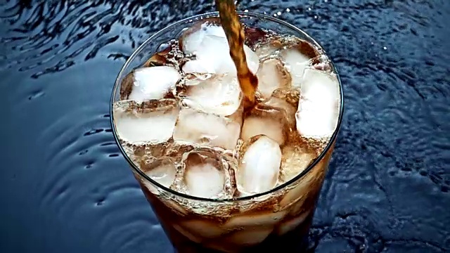 慢动作将可乐苏打倒入冰杯视频素材