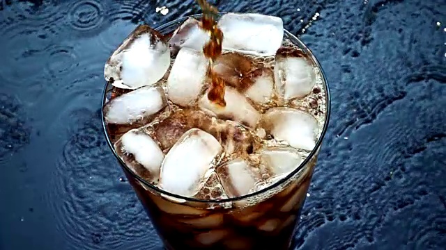 慢动作将可乐苏打倒入冰杯视频素材