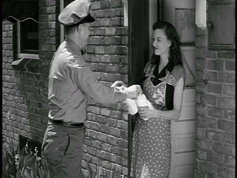 1948年，送奶工与递给他空瓶的家庭主妇交换满瓶的牛奶视频素材