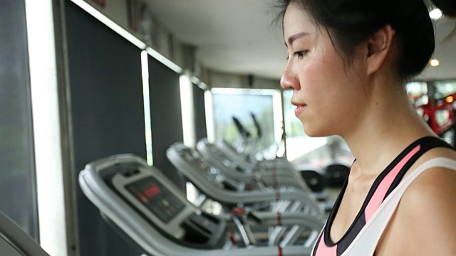 运动女性在跑步机上跑步视频素材