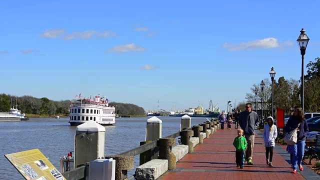 萨凡纳乔治亚河上的游船和人们在萨凡纳河上的滨河步道上散步视频素材