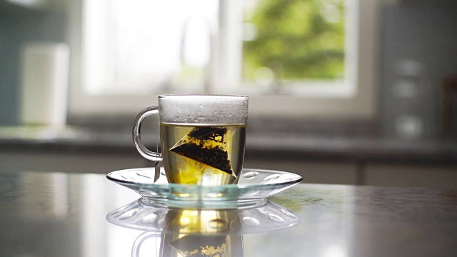 泡茶:将茶包放入热水中视频素材