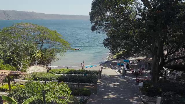 尼加拉瓜的拉古纳阿波约湖度假胜地。做日光浴和沐浴的女人。岸边有皮划艇，水上有木制平台。视频下载