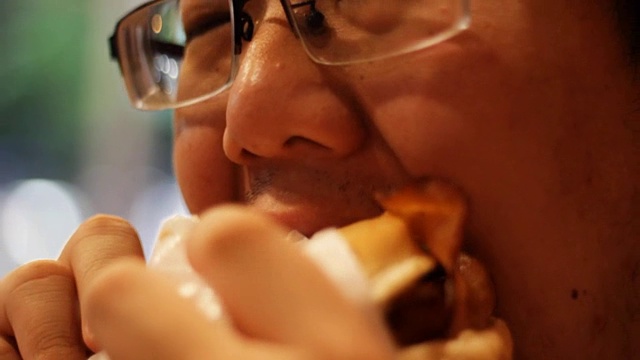 亚洲男人吃汉堡视频素材