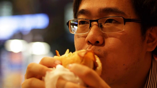亚洲男人吃汉堡视频素材