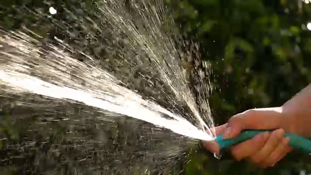 慢镜头，人们在花园里给树浇水视频素材