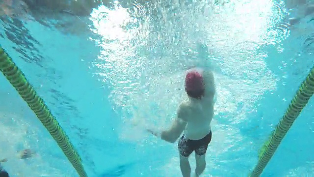在男子仰泳风格比赛游泳者的水下视图视频下载