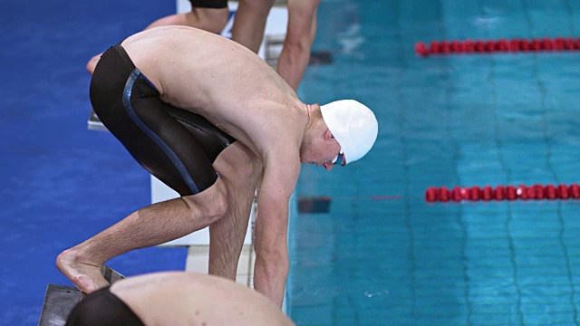 男子游泳运动员在起跑台上的起跑位置视频下载