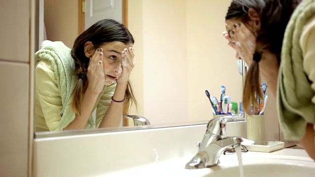 少女在家庭浴室洗脸视频素材