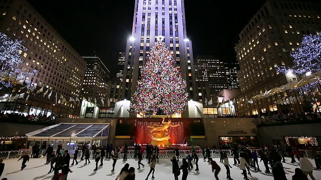 美国纽约，洛克菲勒中心晚上的滑冰者和灯光圣诞树视频下载