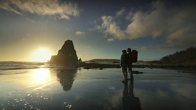 年轻夫妇徒步在太平洋海滩日落视频素材
