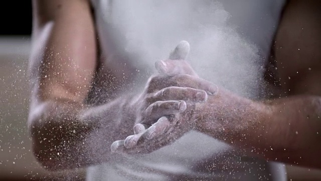 SLO MO体操运动员用粉笔擦他的手视频素材