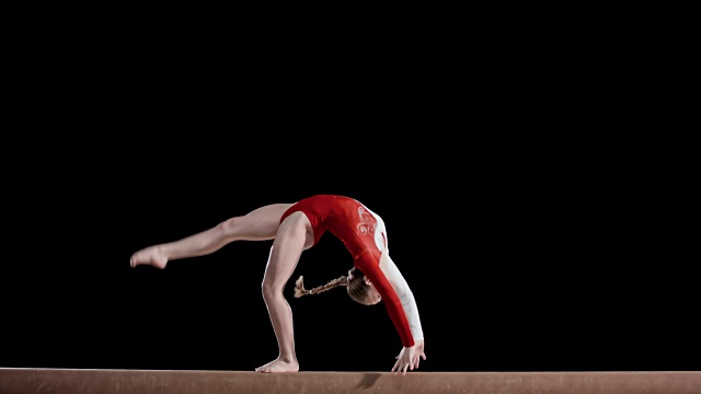 SLO MO女子体操运动员在平衡木上表演一个后肢倒立视频下载
