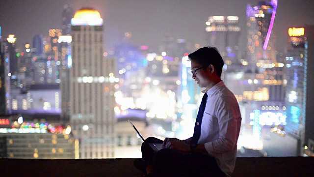 年轻的商人使用笔记本电脑，看城市景观，亚洲视频素材