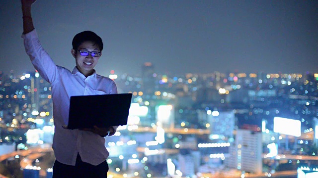 年轻的商人使用笔记本电脑，看城市景观，亚洲视频素材