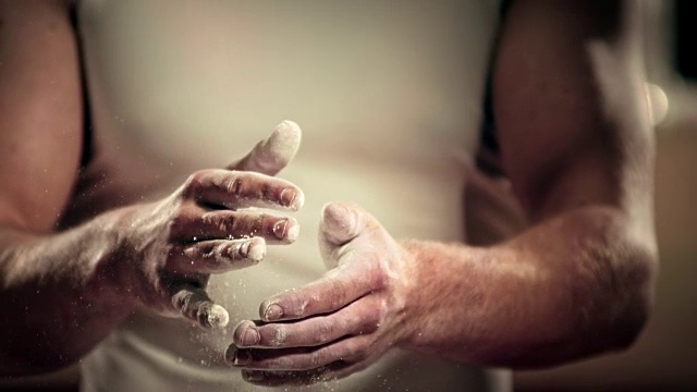 SLO MO男子体操运动员用粉笔画他的手视频素材