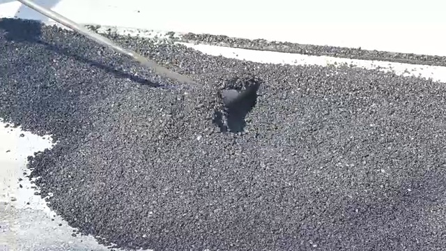 工人修理路面沥青摊铺机，在路面上涂沥青视频下载