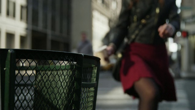 近距离的女人扔咖啡杯在城市垃圾桶/纽约，纽约，美国视频素材