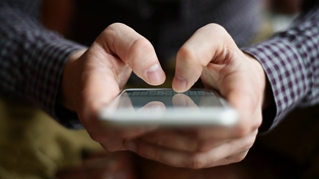 一个年轻人的手指在用智能手机发短信视频素材